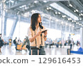 Portrait of standing tourist woman passenger at international airport terminal for holidays travel 129616453