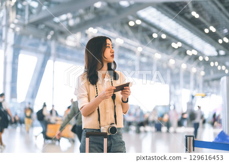 Portrait of standing tourist woman passenger at international airport terminal for holidays travel 129616453
