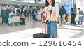 Standing tourist woman passenger at international airport terminal for holidays solo travel 129616454