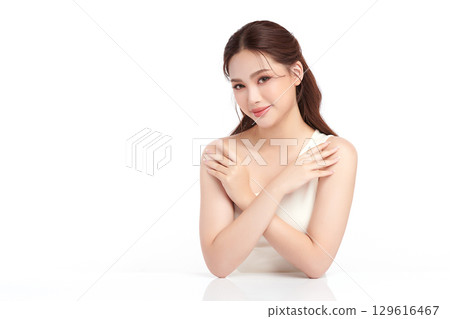 A beautiful young Asian woman with clean, fresh skin against a white background. Skincare, facial treatment, cosmetology, beauty, and spa. An elegant portrait of an Asian woman. 129616467
