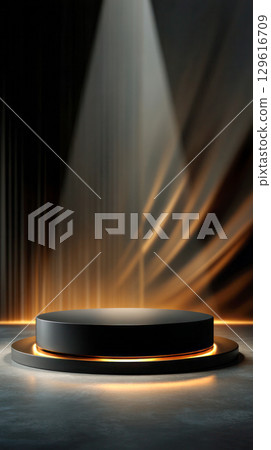 Circular podium illuminated by soft light in a dramatic setting, showcasing a sleek design with warm tones and elegant backdrop for presentations 129616709