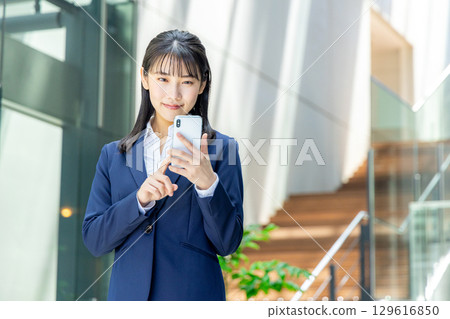 Business woman operating a smartphone 129616850