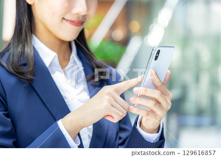 Business woman operating a smartphone 129616857