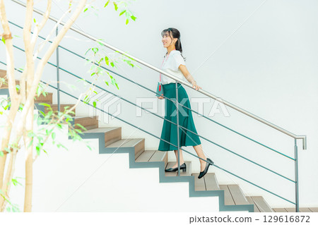 Thinking young woman holding a file 129616872
