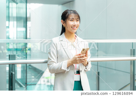 Business woman operating a smartphone 129616894