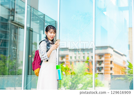 一名在校園裡操作智能手機的大學生 129616909