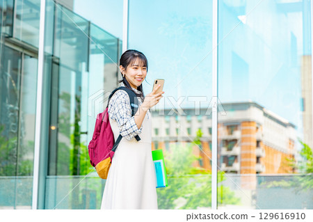 一名在校園裡操作智能手機的大學生 129616910