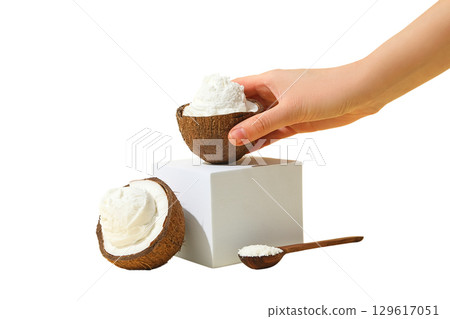 Hand lifts coconut bowl filled with cream, isolated on white, PNG 129617051