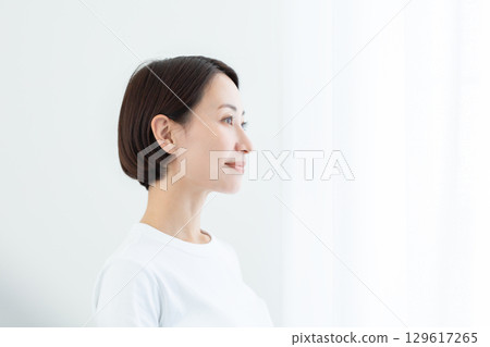 一位目光清澈的女人在燈光下凝視前方 129617265