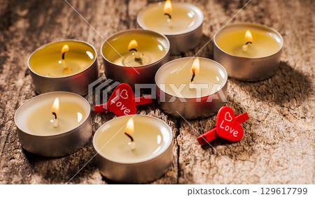 Tealight candles shine steadily on the brown background 129617799