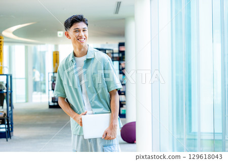 拿著文件的微笑的大學生 129618043