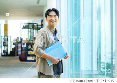 拿著文件的微笑的大學生 129618049