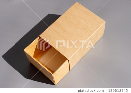 Open brown cardboard box on gray surface with shadow Open brown cardboard box on gray surface with shadow 129618345