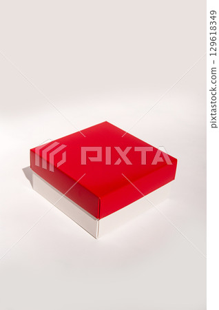 Minimalist red and white box on neutral background highlighting simple design aesthetic. International Box Day Minimalist red and white box on neutral background highlighting simple design aesthetic. International Box Day 129618349