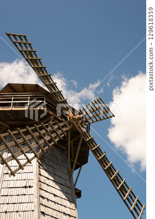 Historic wooden windmill against blue sky Historic wooden windmill against blue sky 129618359