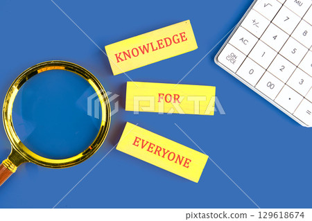 Education Concept text KNOWLEDGE FOR EVERYONE made of wooden blocks on blue background next to calculator, top view 129618674