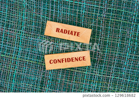 Words RADIATE CONFIDENCE made of wooden blocks on fabric background, top view Words RADIATE CONFIDENCE made of wooden blocks on fabric background, top view 129618682