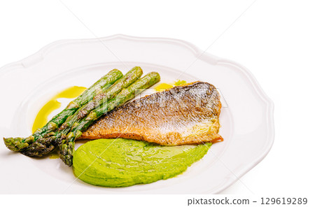 Freshly cooked fish fillet with asparagus and mint puree presented elegantly 129619289