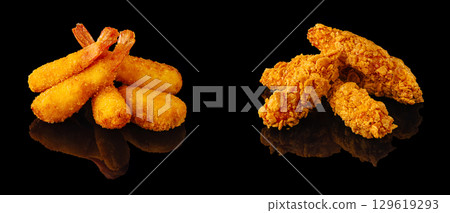Crispy fried shrimp and chicken tenders served on a black background 129619293