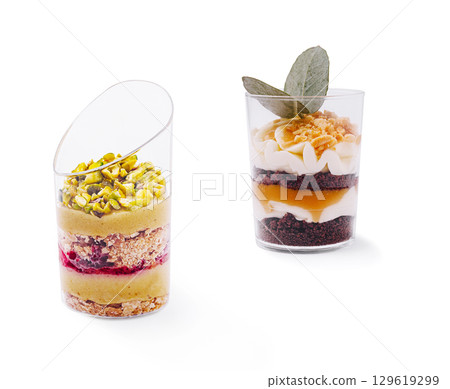 Delicious layered desserts served in transparent cups at a modern bakery Delicious layered desserts served in transparent cups at a modern bakery 129619299