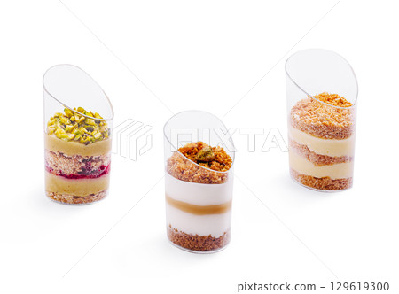 Exquisite layered desserts served in elegant transparent cups at a pastry shop Exquisite layered desserts served in elegant transparent cups at a pastry shop 129619300