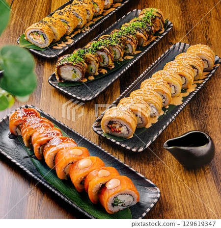Delicious sushi rolls presented on beautiful wooden platters at a restaurant Delicious sushi rolls presented on beautiful wooden platters at a restaurant 129619347