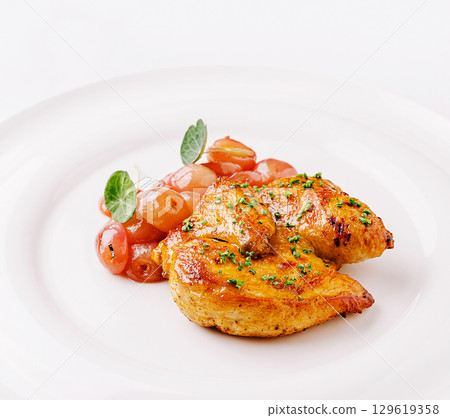 Delicious grilled chicken served with roasted cherry tomatoes and herbs Delicious grilled chicken served with roasted cherry tomatoes and herbs 129619358