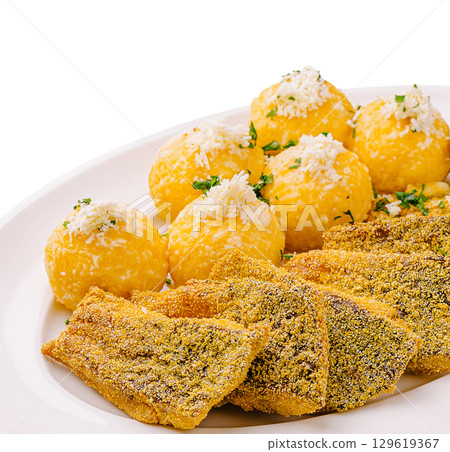 Delicious fried fish served with yellow corn dumplings and cheese 129619367