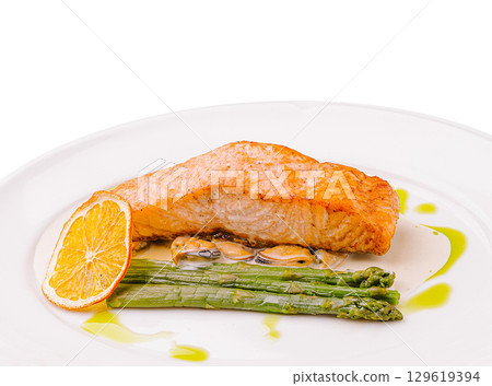 Salmon fillet with asparagus and citrus garnish served on a white plate Salmon fillet with asparagus and citrus garnish served on a white plate 129619394