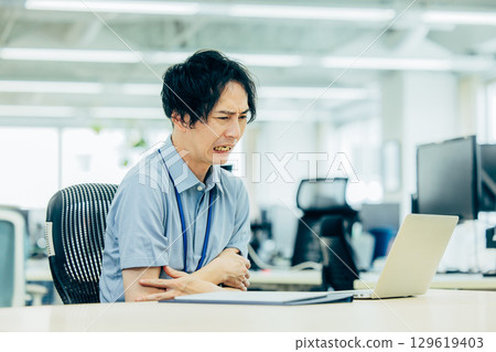 A businessman whose office air conditioning is too cold 129619403
