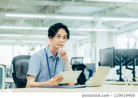 A young businessman heading to a computer in the office 129619409