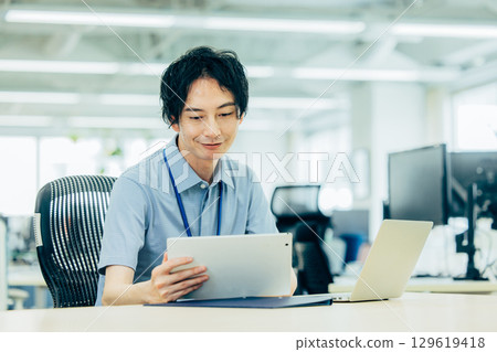 A young businessman heading to a computer in the office 129619418