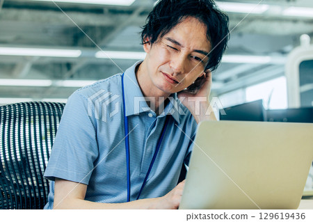 A man who is worried while looking at a computer 129619436