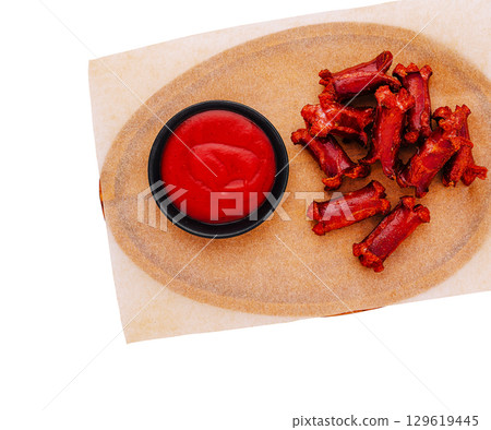 Tasty sausages snacks with red dip served on a wooden platter Tasty sausages snacks with red dip served on a wooden platter 129619445