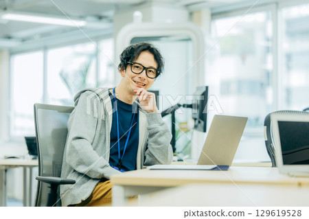 一名男子在辦公室使用電腦 一名男子在辦公室使用電腦 129619528