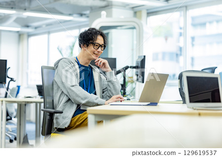 A man working on a computer at work A man working on a computer at work 129619537
