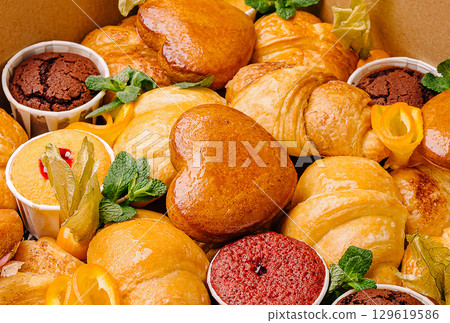 Delicious assortment of pastries and desserts in a decorative box Delicious assortment of pastries and desserts in a decorative box 129619586