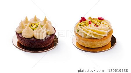 Decadent desserts featuring pistachio and cream toppings on elegant bases Decadent desserts featuring pistachio and cream toppings on elegant bases 129619588