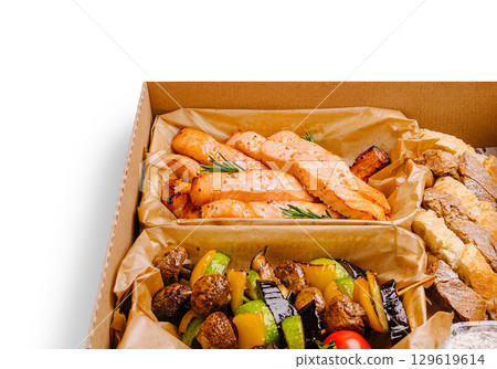 Healthy grilled salmon with vegetables in a takeout box from a local restaurant 129619614