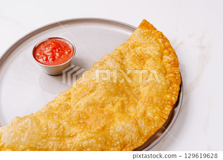 Crispy snack served with tangy sauce on a plate at a local eatery 129619628