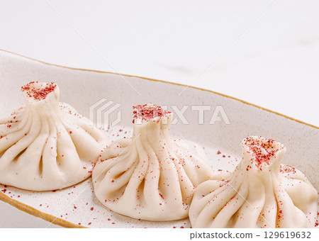 Delicious khinkali served on a decorative plate in a modern setting Delicious khinkali served on a decorative plate in a modern setting 129619632