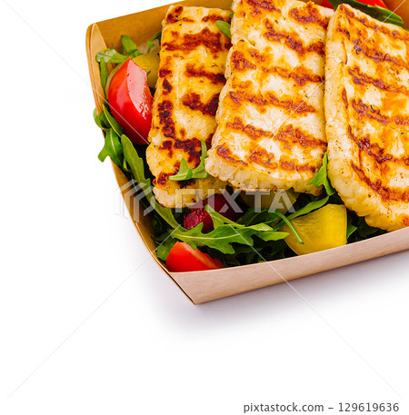 Grilled cheese platter served with fresh salad on a sunny day outdoors 129619636