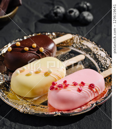 Delicious handmade ice cream pops displayed on a decorative plate Delicious handmade ice cream pops displayed on a decorative plate 129619641