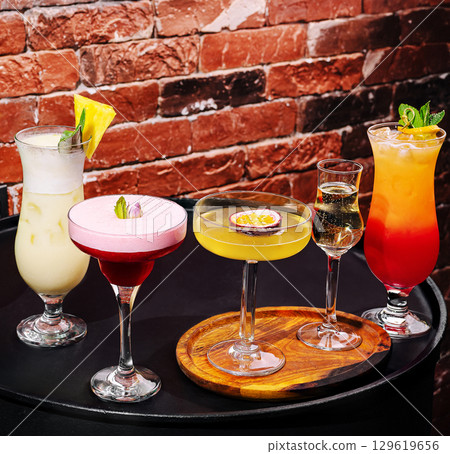 Colorful cocktails served on a wooden platter at a vibrant bar setting Colorful cocktails served on a wooden platter at a vibrant bar setting 129619656