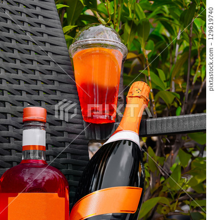 Party drinks displayed on a garden table with vibrant green foliage Party drinks displayed on a garden table with vibrant green foliage 129619740