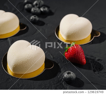 Heart-shaped desserts with fresh berries on a dark slate surface Heart-shaped desserts with fresh berries on a dark slate surface 129619749