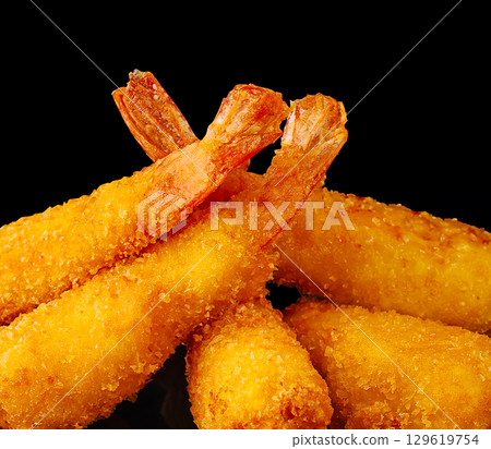 Crispy shrimp rolls served with dipping sauce on a dark background 129619754