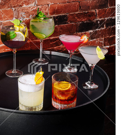 Colorful cocktails displayed on a round black table in a vibrant setting 129619800