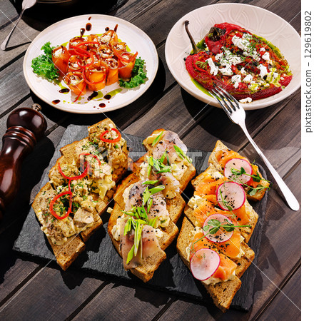 Delicious assortment of gourmet appetizers on a wooden table 129619802