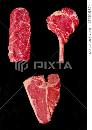Different cuts of raw meat displayed creatively on black background Different cuts of raw meat displayed creatively on black background 129619804